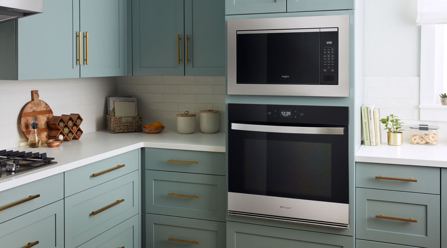 A kitchen with a built-in microwave above a wall oven