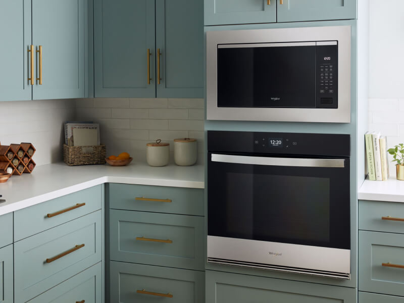 A kitchen with a built-in microwave above a wall oven