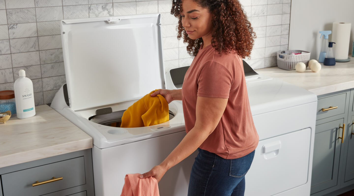 Person removing clothes from a top load washing machine