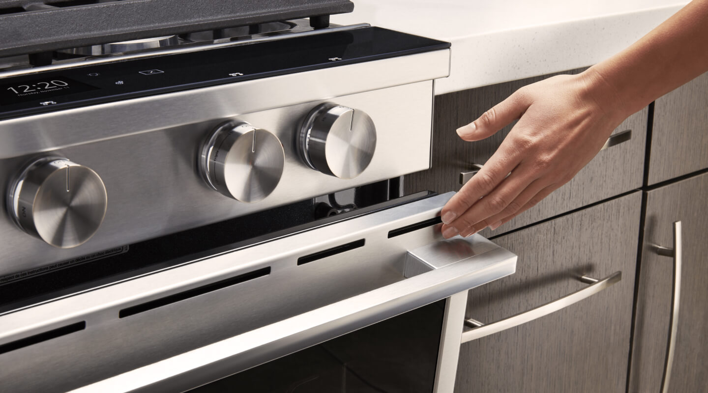 Person closing the door of a gas oven