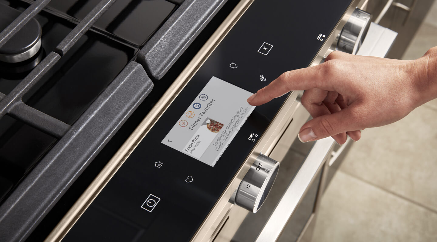 Person selecting touch screen settings on a gas oven