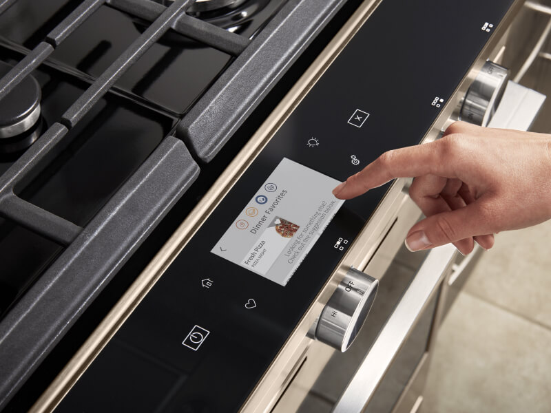 Person selecting touch screen settings on a gas oven
