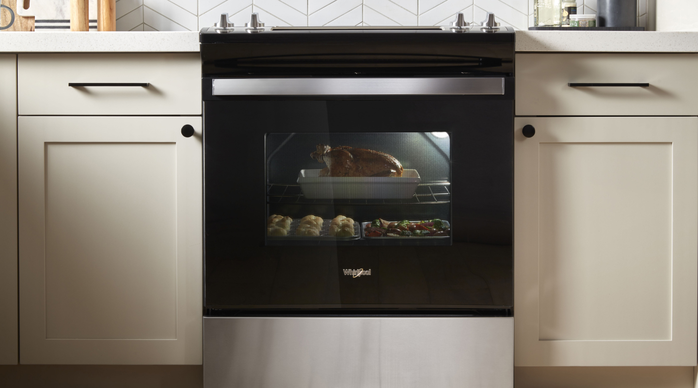 A chicken dinner roasting in an oven