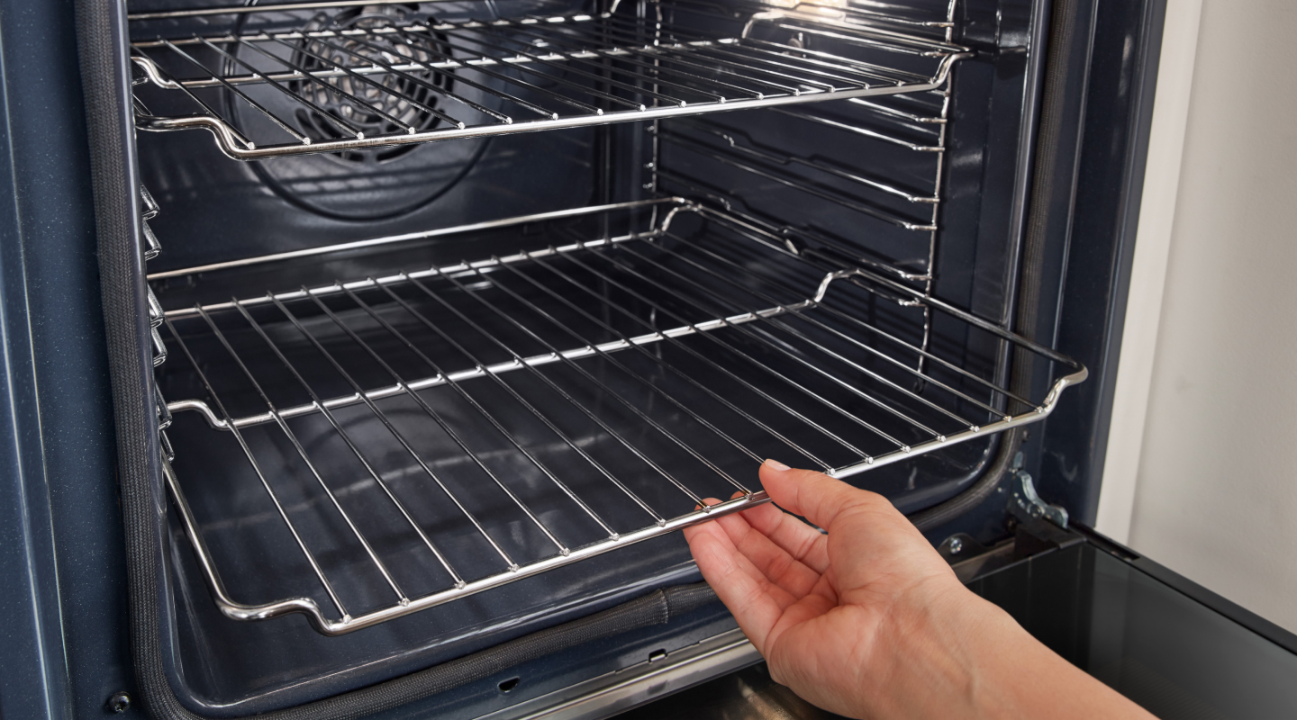 Person pulling out lower oven rack