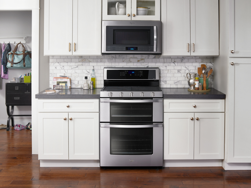 Silver double oven set into white cabinetry
