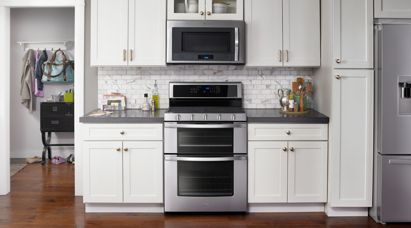 Silver double oven set into white cabinetry