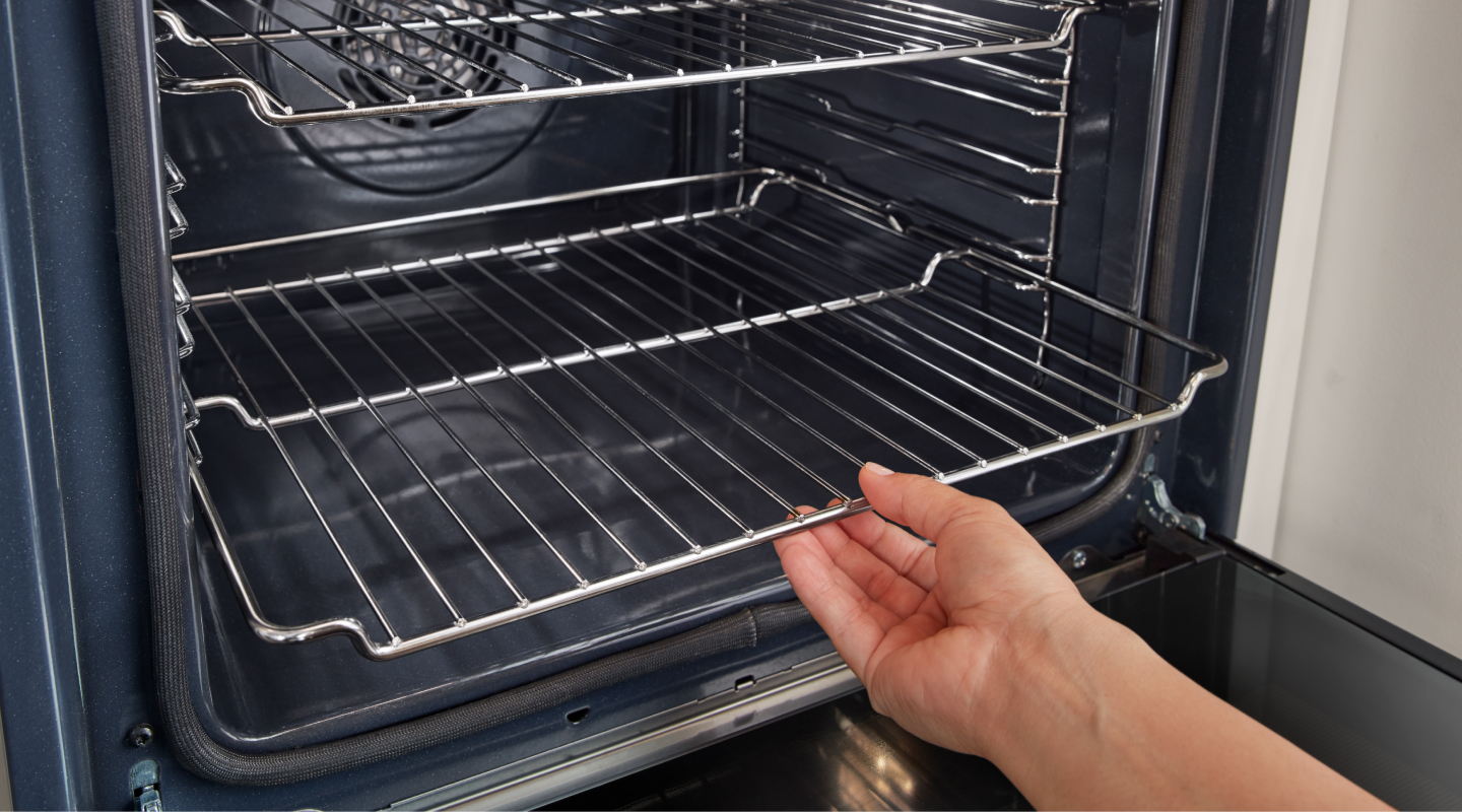 Hand removing racks from inside oven