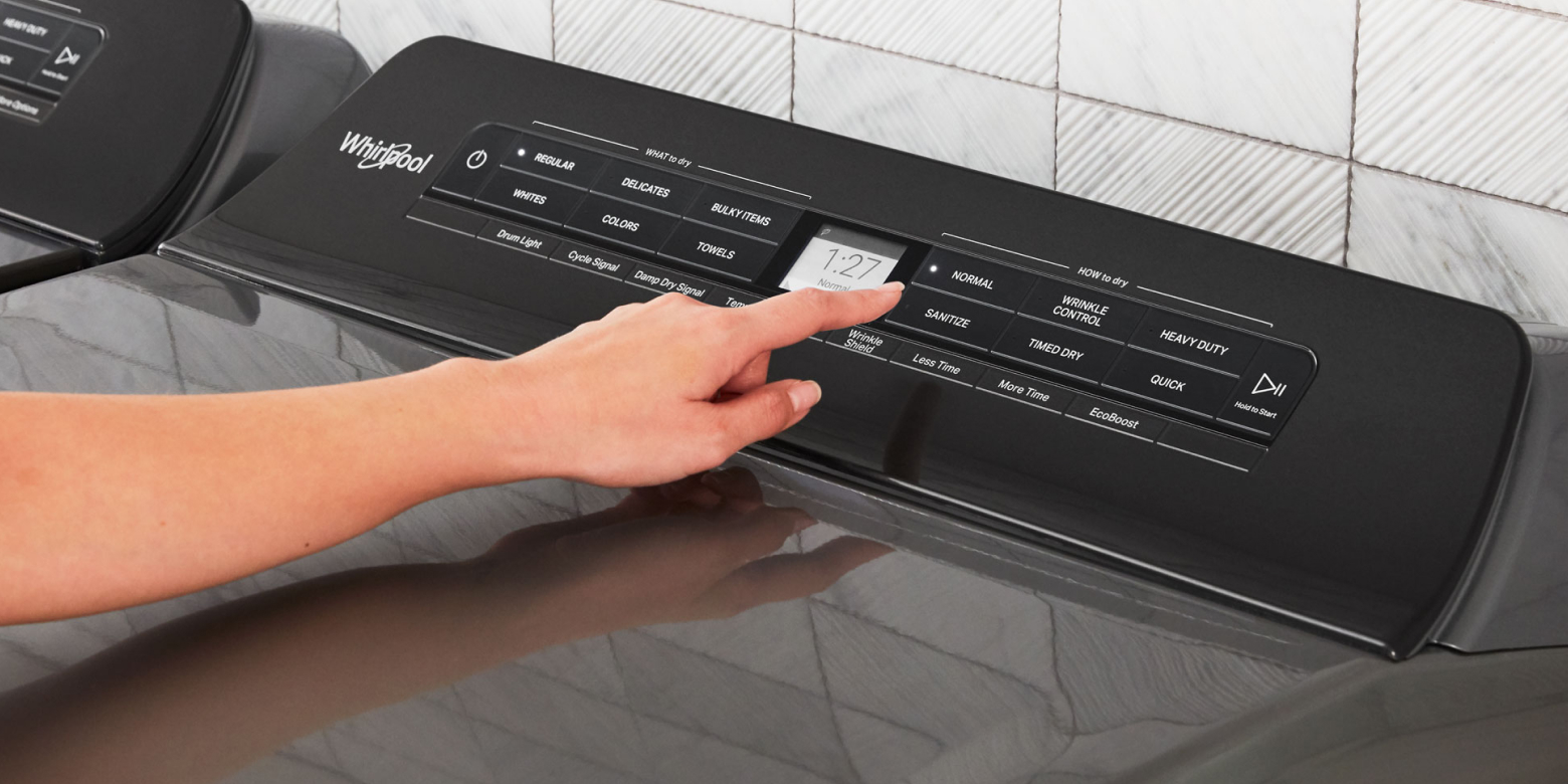 Person selecting a dryer cycle on a Whirlpool® dryer