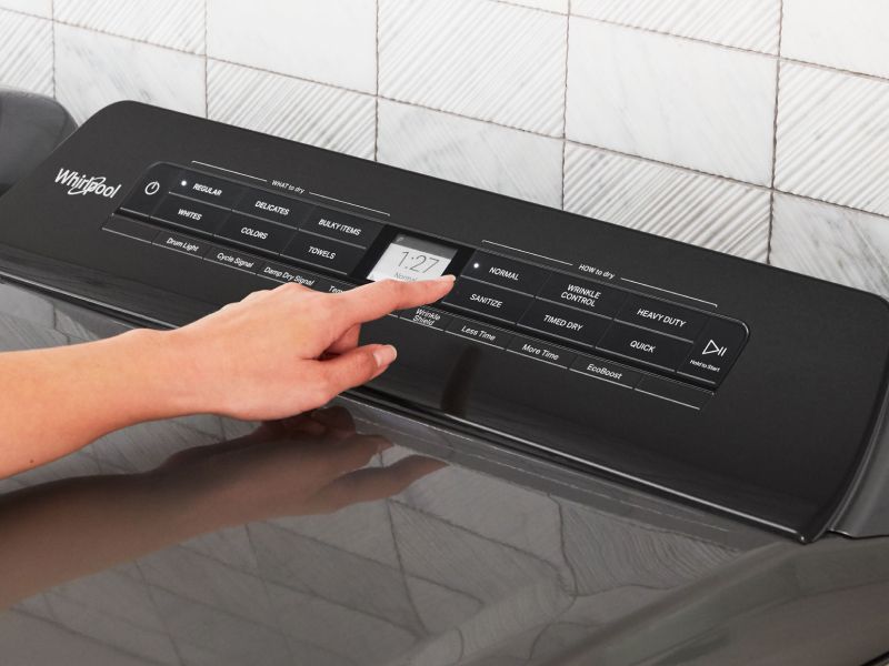 Person selecting a dryer cycle on a Whirlpool® dryer