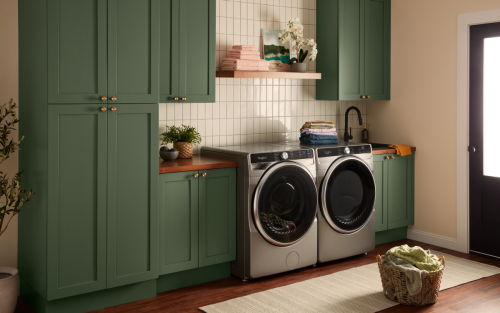 Silver front load Whirlpool® Washer and Dryer set in green cabinetry