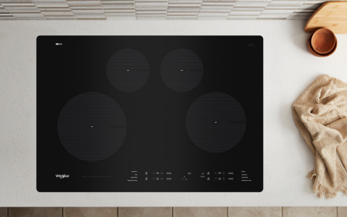 Whirlpool® Electric Cooktop next to kitchen towel on countertop