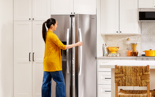 Person opening a stainless steel refrigerator