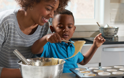 A woman and toddler cooking together in a kitchen