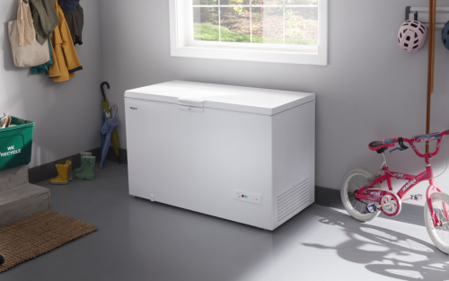 A white chest freezer sitting in a basement