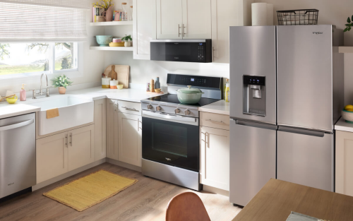 Interior shot of a kitchen with a stainless steel stove, microwave and refrigerator