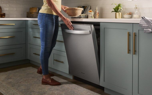 Person closing a stainless steel Whirlpool® Dishwasher