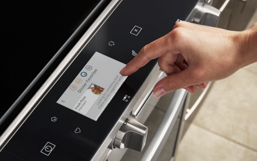 Person selecting settings on an oven touch screen control panel