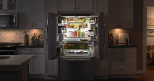 Open French door refrigerator filled with groceries