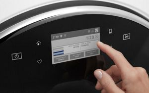Person selecting a setting on a washing machine control panel