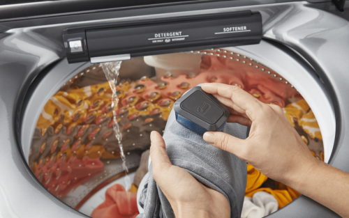 Hand scrubbing stains out of clothes at a washing machine pretreat station