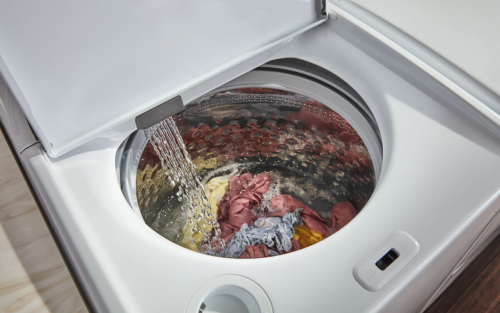 An open washer filling with water
