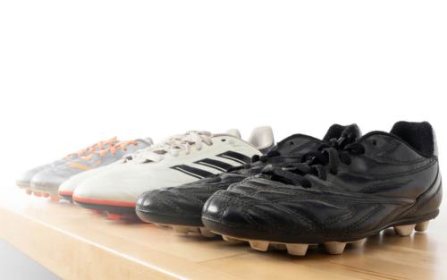 Various cleats lined up for cleaning