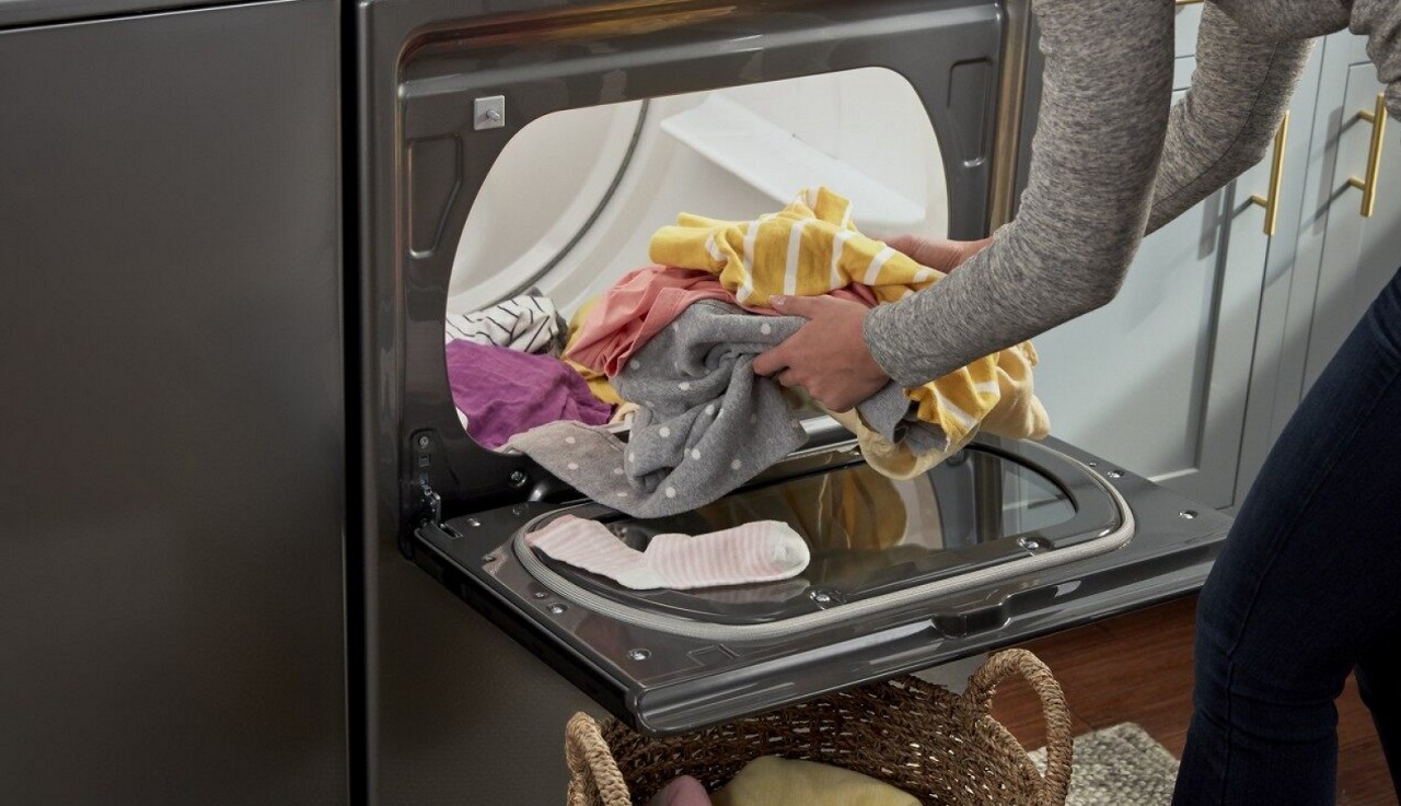 A person unloading clothes from a dryer