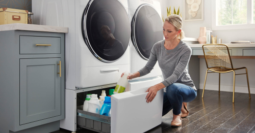  A woman placing laundry detergent in a washer pedestal