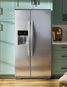 A Whirlpool® Refrigerator in a kitchen with teal cabinets.