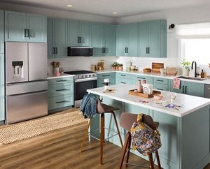 A kitchen with Whirlpool® Appliances and teal cabinets.